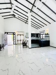 a large room with white floors and a large ceiling at Fanisha Family Villa and Restaurant in Negombo