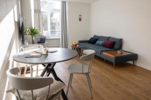 a living room with a table and a couch at FID B' Home, appartement Cosy entre Mulhouse et Colmar in Guebwiller