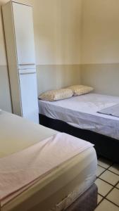 a room with two beds and a refrigerator at Casa Amarela in João Pessoa