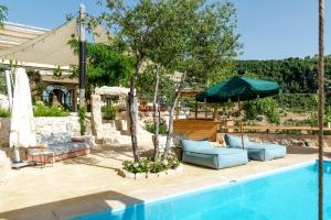 a swimming pool with chairs and an umbrella next to a pool at Casadar Guesthouse in Ash Shi‘b +66 photos