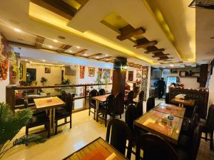 un ristorante con tavoli e sedie e un bar di Hotel Shraddha Palace a Kathmandu
