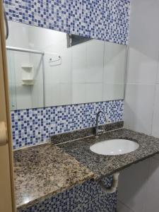 a bathroom with a sink and blue and white tiles at Casa Amarela in João Pessoa
