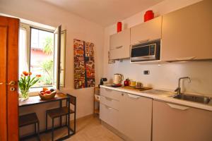 a kitchen with white cabinets and a table and a window at La Casa di Apollo in Naples