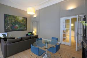 sala de estar con sofá, mesa y sillas en Aparthotel Liège en Lieja