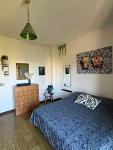 a bedroom with a bed and a dresser and a mirror at Ambrazzurra Apartament in Aci Castello