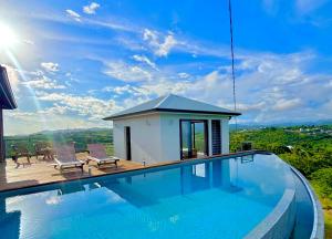 a villa with a swimming pool and a house at Villa Vincent des Caps in Le Marin