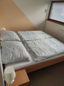 a bed in a room with two pillows on it at Apartmán v Bečva Resortu in Horní Bečva