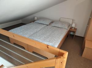 a bedroom with a wooden bed with two pillows at Apartmán v Bečva Resortu in Horní Bečva +5 photos
