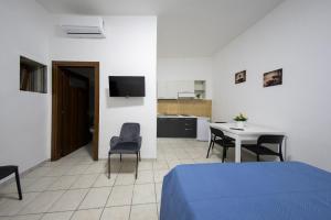 a room with a bed and a table and a kitchen at AFFITTACAMERE al CASTELLO AIROLA BN in Airola