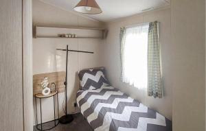 heinkenszandにある3 Bedroom Lovely Home In Heinkenszandのベッドと窓のある小さな部屋