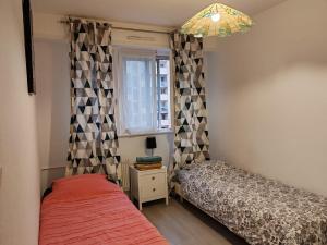 een slaapkamer met twee bedden en een raam bij Spacieux et lumineux T5 avec 4 chambres, au centre-ville de Mulhouse, grand balcon, grand écran plat in Mulhouse