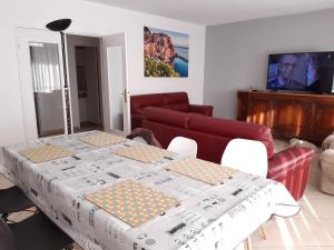 een woonkamer met een tafel en een bank bij Spacieux et lumineux T5 avec 4 chambres, au centre-ville de Mulhouse, grand balcon, grand écran plat in Mulhouse