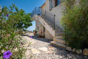 a staircase leading up to a building with purple flowers at Bee Tree Villa in Corfu