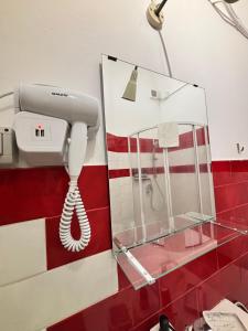 a phone on a wall next to a red wall at Il Teatro Rooms in Catania +72 photos