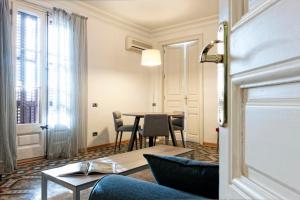 een woonkamer met een tafel en stoelen bij MH Apartments Tetuan in Barcelona