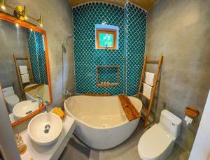 a bathroom with a tub and a toilet and a sink at Blue Tropical House Hội An in Hoi An +90 photos