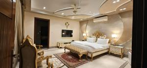 a bedroom with a king sized bed and a chair at Avenue-3 Guest House in Islamabad +18 photos