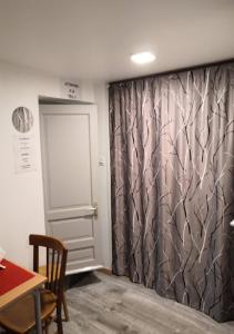 una sala da pranzo con tavolo e tenda di Mini STUDIO a Marsannay-la-Côte