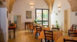 um restaurante com mesas e cadeiras num quarto em B&B La Garolla em Sannicola