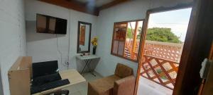 a room with a desk with a laptop and a balcony at Cabaña Barbacoas in Santa Ana