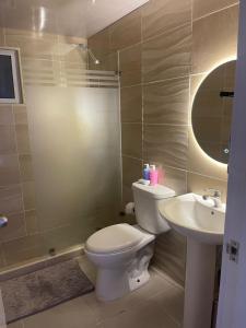 a bathroom with a toilet and a sink at Modern and Cozy 3-Bedroom Apartment in Santo Domingo in Los Paredones