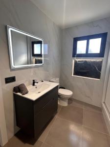 a bathroom with a sink and a toilet and a mirror at Casa maría in Costa Teguise +3 photos