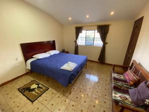 Finca la Magdalena ''Jacuzzi, naturaleza en la casona'' في Hacienda Conraquí: غرفة نوم بها سرير مع لحاف أزرق