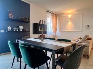 Un comedor con una mesa y sillas verdes. en Velvet Apartment, en Verona