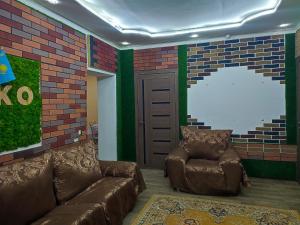 a living room with a couch and a chair at "Aiko" Қонақ Отбасы 2 in Shymkent