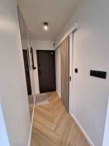 a hallway with a mirror and a door at Własne M Studio in Konin