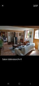 a living room with a large white couch in a room at La p'etit maison rose in Malouy