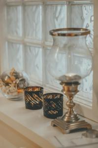 a glass vase and three candles on a shelf at The Black Isle Retreat in Inverness +23 photos