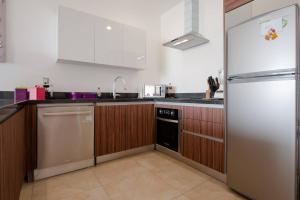 a kitchen with a refrigerator and a dishwasher at Central Luxury Apartment Playa del Carmen in Playa del Carmen