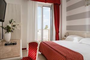 a hotel room with a bed and a window at Hotel Du Soleil in Rimini