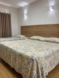 two beds in a hotel room with two beds at Hotel Nascentes da Serra in Poços de Caldas
