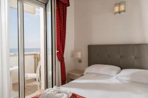 a bedroom with a bed and a view of the ocean at Hotel Du Soleil in Rimini