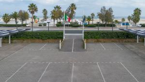 a parking lot with two flags in a parking lot at Hotel Du Soleil in Rimini