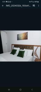 a bedroom with a white bed with green pillows at Villa Maria Appartement 1 in Sali Nianiaral +72 photos