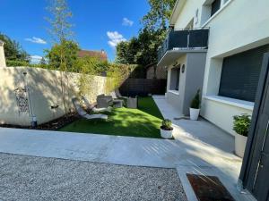 a small garden with a chair in a yard at Chambre Premium "Plume"- SDB privée & coin repas in Sainte-Geneviève-des-Bois +3 photos