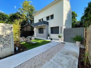 a white house with a fence and a yard at Chambre Premium "Plume"- SDB privée & coin repas in Sainte-Geneviève-des-Bois