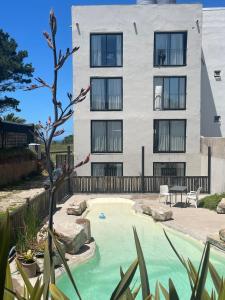 a building with a swimming pool in front of a building at Faro Aparts in Mar del Plata