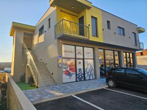 a building with a car parked in a parking lot at Imperial rooms in Mostar