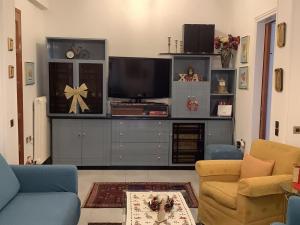 sala de estar con TV en un centro de entretenimiento en Feel Home Cozy, en Volos