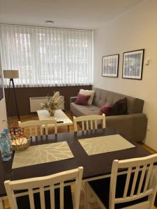 a living room with a table and a couch at Apartman Zotović in Sarajevo