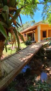 un pont en bois devant une maison dans l'établissement Casa de campo Sanloá, à Parati