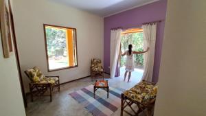 une femme debout dans une pièce donnant par la fenêtre dans l'établissement Casa de campo Sanloá, à Parati 16 autres photos