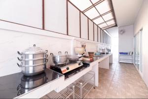 a kitchen with a counter with pots and pans at 91 Smile Pool Villa Sattahip in Ban Tao Than