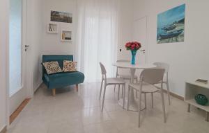 a dining room with a table and chairs and a vase of flowers at ROUTE 96 Guest House in Modugno +15 photos