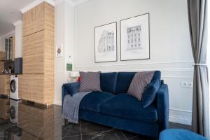 a blue couch in a living room with paintings on the wall at Le Parisien de COUP DE COEUR APPARTEMENTS in Valencia