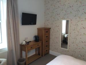 a bedroom with a bed and a dresser at Portreath Arms in Portreath
